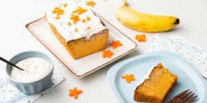 Karottenkuchen mit Sternkarotten als Topping und Banane im Hintergrund