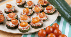 Glutenfreie Kinderpizza: Mini Zucchini Pizza Scheiben belegt mit Tomatensoße, Käse und Tomaten