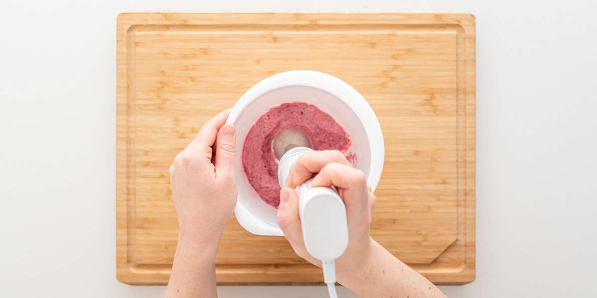 Rosa Aufstrich wird mit Stabmixer in Schüssel gemixt für das Gemüse-Sandwich.