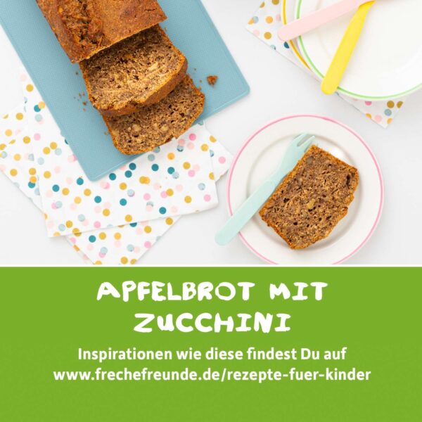 Freche Freunde Rezepttipp: Ein aufgeschnittenes Apfel-Zucchini-Brot auf einem hellblauen Brett mit bunten Servietten und Tellern. Das Bild lädt zum Nachbacken ein – kreative Inspirationen findest du unter www.frechefreunde.de/rezepte-fuer-kinder.