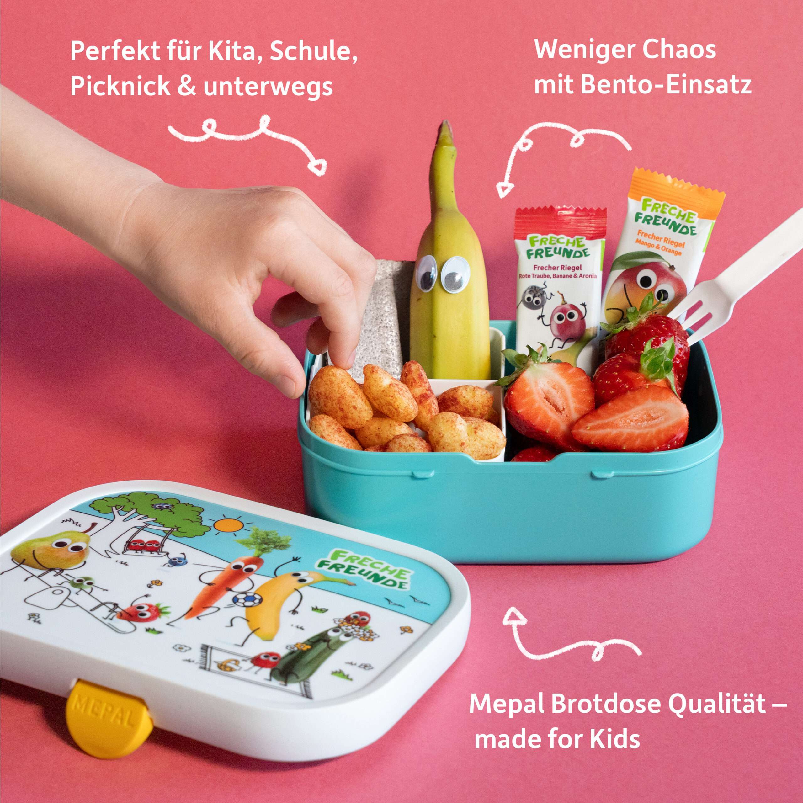 Eine Kinderhand greift zu einem Snack aus der offenen Freche-Freunde-Brotdose. Drinnen steckt eine freche Banane mit Wackelaugen, Erdbeeren, ein Müsliriegel von Freche Freunde und knusprige Ringe – alles schön sortiert dank praktischem Bento-Einsatz. Die Brotdose mit fröhlichem Design zeigt unsere Charaktere beim Spielen – Mepal-Qualität made for Kids!