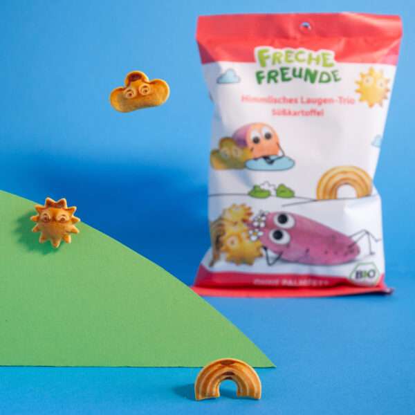 Freche Freunde Himmlisches Laugen-Trio Süßkartoffel auf blau- grünem Hintergrund. Daneben je eine Laugewolke, Laugen-Regenbogen, Laugensonne.