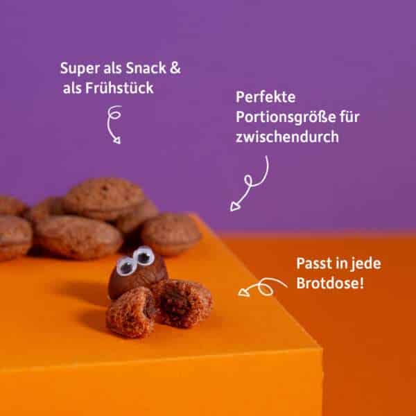 Freche Freunde Kids Bio Crunchy Bits mit Produktvorteile: Super als Snack & als Frühstück, Perfekte Portionsgröße für Zwischendurch, Passt in jede Brotdose auf Lila, orangenem Hintergrund.