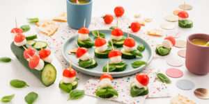 Freche Freunde Glückspilze mit Gurkenscheiben, Basilikum, kleine Mozzarella Kugeln, halbe Cherrytomaten aufgespießt auf Zahnstochern