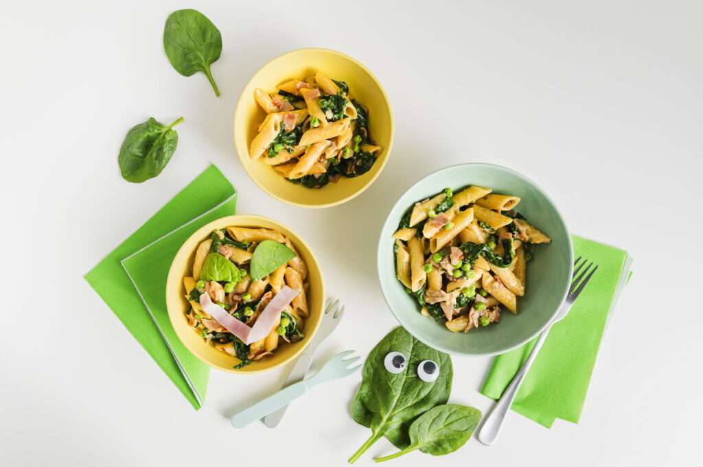 Spinat Pasta mit Schinken in Schüsseln serviert