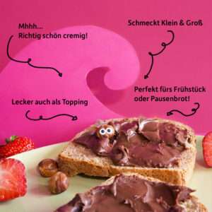 Zwei Scheiben Brot mit der Freche Freunde Kids Bio Haselnuss-Kakao-Creme bestrichen, dekoriert mit Erdbeeren und einem frechen Haselnuss-Charakter, der aus der Creme herauslugt. Text auf dem Bild: „Mhmm… richtig schön cremig!“, „Perfekt fürs Frühstück oder Pausenbrot!“, „Lecker auch als Topping“, „Schmeckt Klein & Groß“.