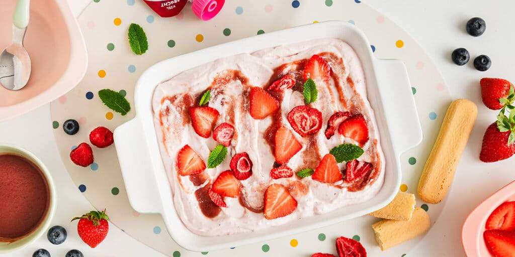 Erdbeer Tiramisu in einer Form angerichtet mit frischen Erdbeeren und Fruchtmus.