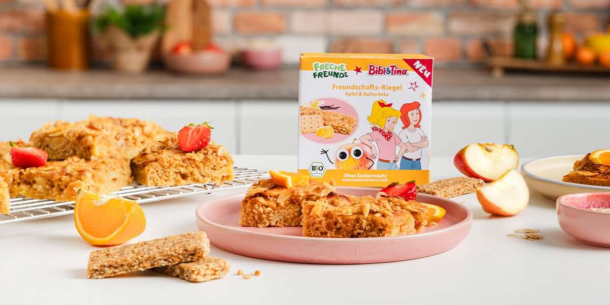 Butterkuchen auf einem Teller serviert mit Freche Freunde Bibi & Tina Riegel und frischem Apfel.